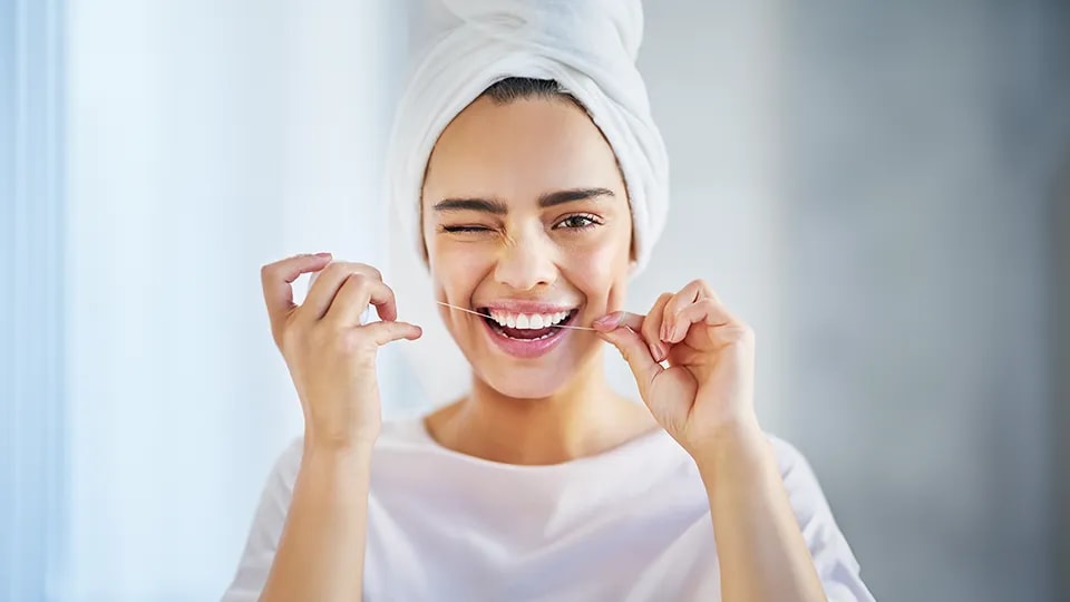 Lady flossing teeth