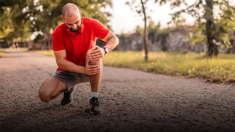 Runner holding his knee in pain