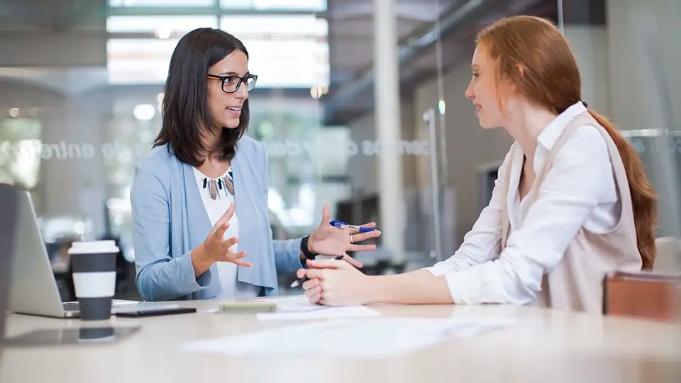 Two professional women talking in an office
