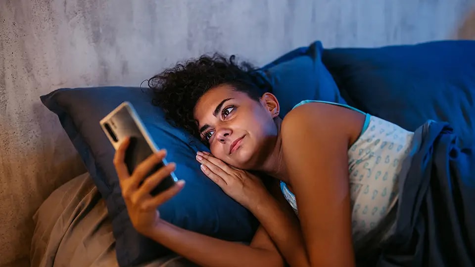 Woman lying down checking her phone