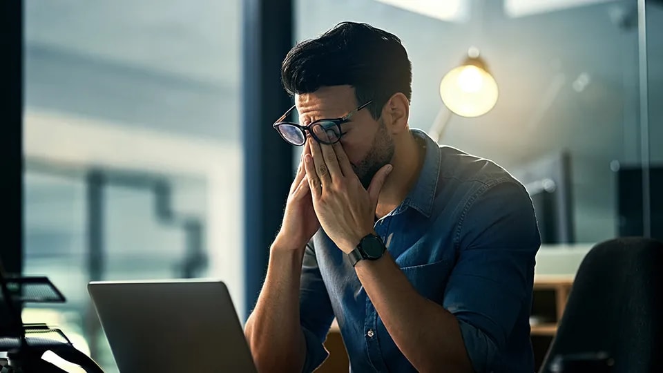 Man looking stressed at work with his hands on his head