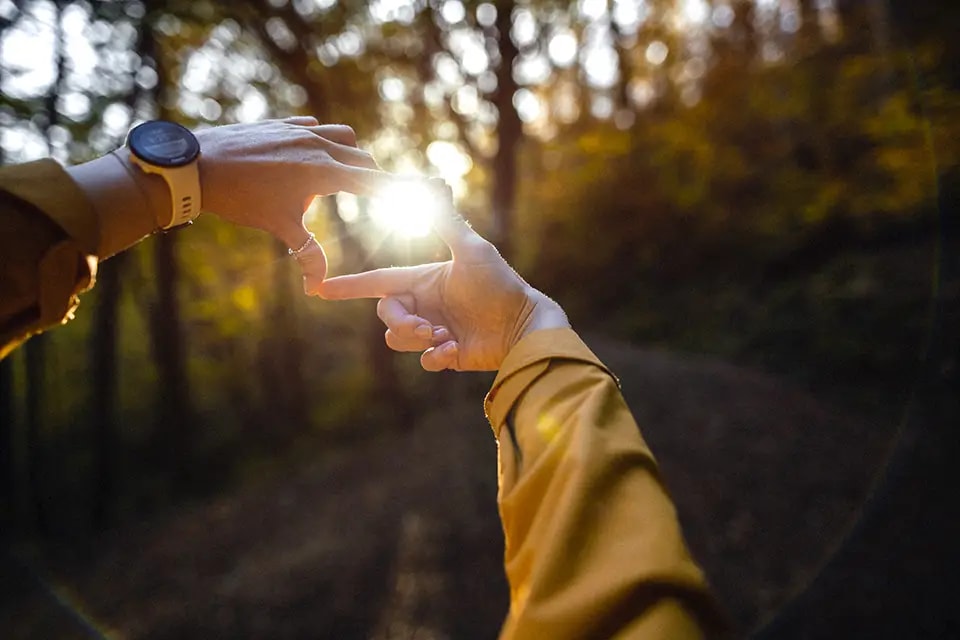 Hands forming a heart shape around the sun