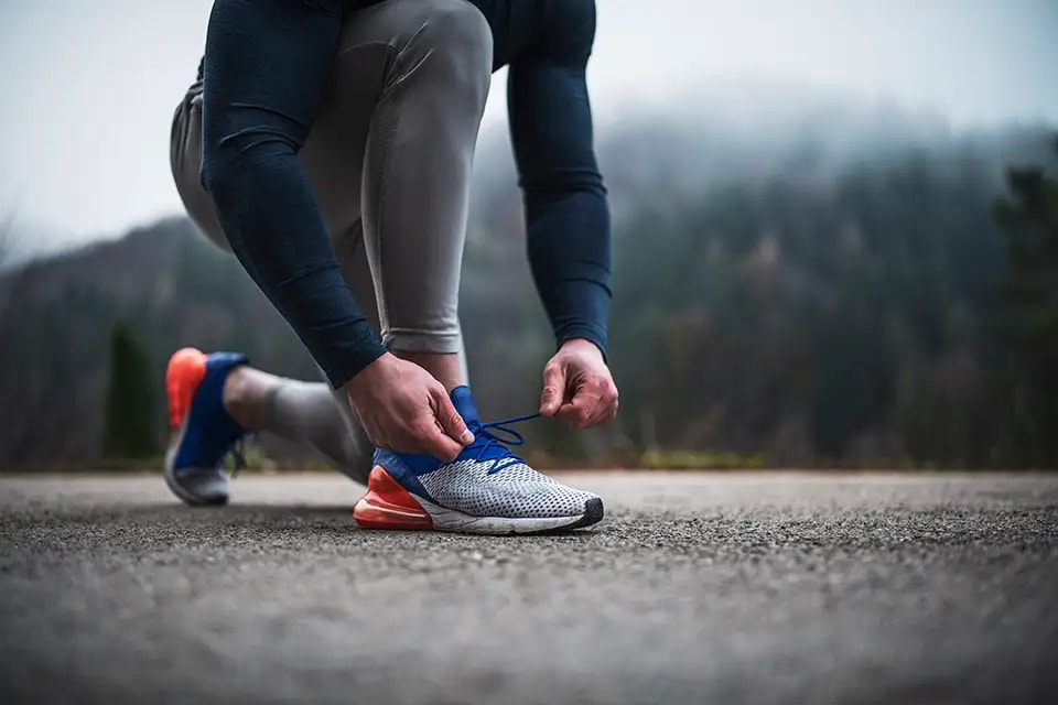 A runner tying their shoe laces